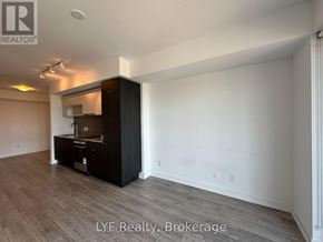 Toronto (Cabbagetown-South St. James Town) condo for rent - A spacious room with a kitchenette and wooden flooring.