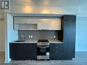 Toronto (Cabbagetown-South St. James Town) condo for rent - A modern kitchen with dark wood cabinets and stainless steel appliances.