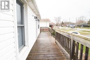 Welland (N. Welland) apartment for rent - A wooden deck leads to a white house with a RE/MAX Escarpment Realty logo.