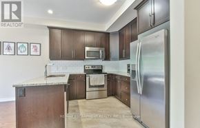 London North (North B) townhouse for rent - A kitchen with a refrigerator, microwave, oven and cabinets.