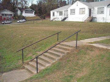 Birmingham apartment for rent - A set of stairs with a metal railing lead up to a white house.