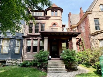 Louisville apartment for rent - A large house with a front porch and a staircase leading to the entrance.