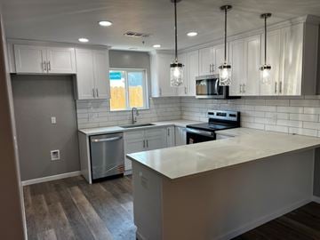 Tulare apartment for rent - A kitchen with a white counter top and stainless steel appliances.