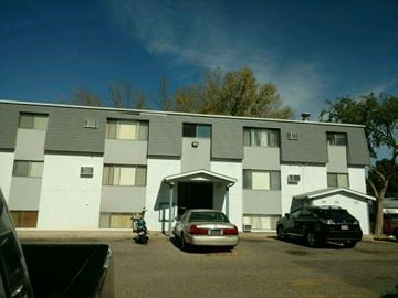 Pubelo apartment for rent - A grey building with a car parked in front.