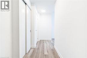 Kitchener condo for rent - A hallway with wood flooring and white walls.