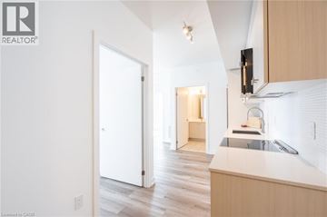 Kitchener condo for rent - A kitchen with a sink and a refrigerator.