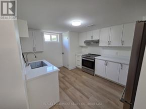 St. Catharines (Secord Woods) apartment for rent - A kitchen with white cabinets and a wooden floor.
