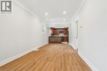 Hamilton apartment for rent - A long hallway with wood floors and a kitchen area in the distance.