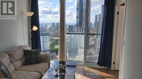 Toronto (Waterfront Communities) condo for rent - A living room with a view of the cityscape through the windows.