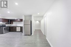 Oshawa (Taunton) apartment for rent - A spacious kitchen with dark wood cabinets and stainless steel appliances.