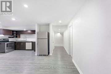 Oshawa (Taunton) apartment for rent - A spacious kitchen with dark wood cabinets and stainless steel appliances.