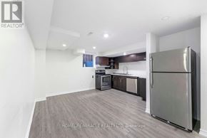 Oshawa (Taunton) apartment for rent - A kitchen with a refrigerator, cabinets, and a countertop is shown in this image.