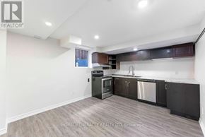 Oshawa (Taunton) apartment for rent - A kitchen with a stainless steel dishwasher and oven, and wooden cabinets.