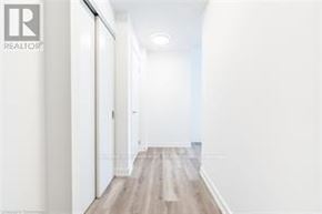 Kitchener condo for rent - A long hallway with wood floors and white walls.
