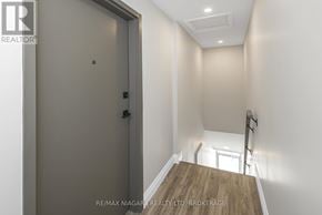 Port Colborne (Sugarloaf) apartment for rent - A hallway with a wooden floor leading to a door.