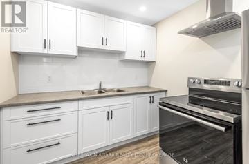 Port Colborne (Sugarloaf) apartment for rent - A kitchen with white cabinets and a stainless steel oven.