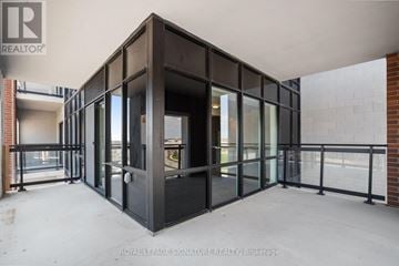 Clarington (Bowmanville) condo for rent - A large, empty room with a glass door and windows.