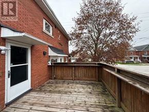 St. Thomas apartment for rent - A wooden deck with a white door and a tree in the background.