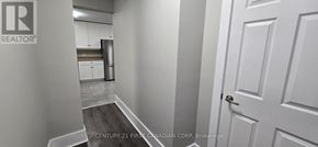 St. Thomas apartment for rent - A hallway with a door on the right and a kitchen in the background.