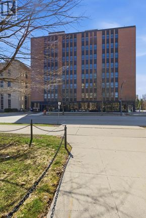 London East (East F) condo for rent - A tall brick building with a black fence in front.