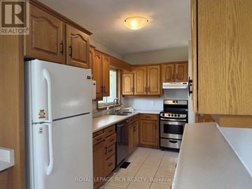 Caledon (Caledon East) apartment for rent - A kitchen with wooden cabinets and a white refrigerator.