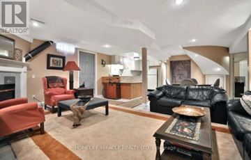 Mississauga (Erin Mills) apartment for rent - A living room with a black leather couch and a coffee table with a tray on it.