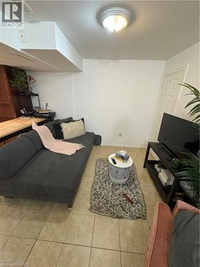 Hamilton apartment for rent - A living room with a grey couch and a black television.
