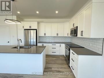 Mcnab/Braeside multi-family for rent - A modern kitchen with white cabinets and a stainless steel refrigerator.
