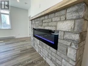 Mcnab/Braeside multi-family for rent - A stone fireplace with a flat screen TV embedded in it.