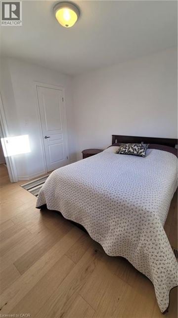Hamilton apartment for rent - A bedroom with a bed, pillow, and a door.