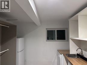 West Vancouver apartment for rent - A small kitchen with a white refrigerator and a window.