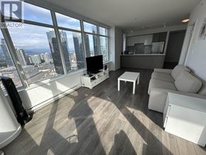 Burnaby apartment for rent - A living room with a large window overlooking a cityscape.