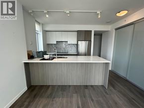 Burnaby apartment for rent - A modern kitchen with a wooden floor and a white countertop.