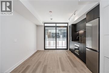 Hamilton condo for rent - A modern kitchen with a stainless steel refrigerator and wooden flooring.