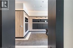 Hamilton condo for rent - A hallway with a wooden door and a black and white tiled wall.