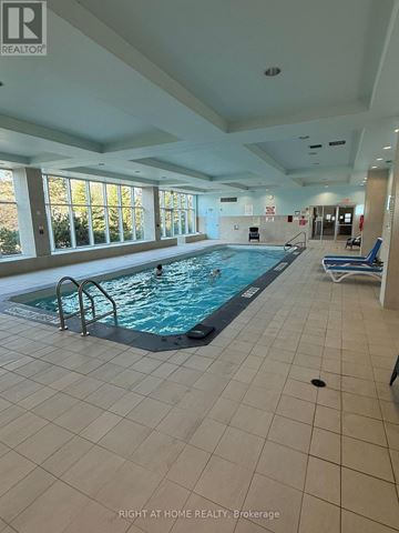 Ottawa condo for rent - A large indoor swimming pool with a sunny view outside.