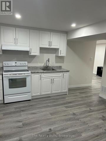 Brampton (Heart Lake East) apartment for rent - A kitchen with white cabinets and a stove top oven.