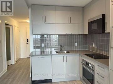 Markham (Unionville) condo for rent - A kitchen with white cabinets and a black fridge.