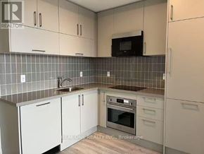 Markham (Unionville) condo for rent - A kitchen with white cabinets and a black microwave above the stove.