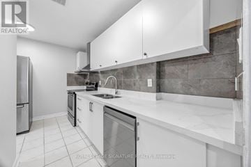 Toronto (Morningside) townhouse for rent - A modern kitchen with white cabinets and a marble countertop.