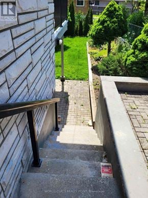 Toronto (Bendale) apartment for rent - A set of stairs leading up to a grassy area with a bench on the left side.