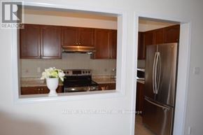 Vaughan (Patterson) apartment for rent - A kitchen with brown cabinets and a stainless steel refrigerator.