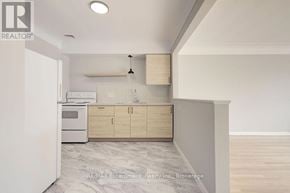 Burlington (Brant) multi-family for rent - A kitchen with a white oven and wooden cabinets.