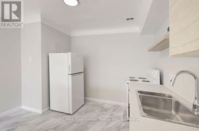 Burlington (Brant) multi-family for rent - A kitchen with a white fridge, stove, and sink.