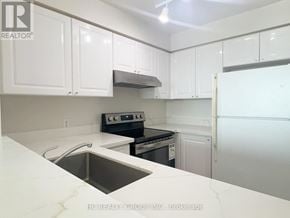 Toronto (Woburn) condo for rent - A kitchen with white cabinets and a stainless steel sink.
