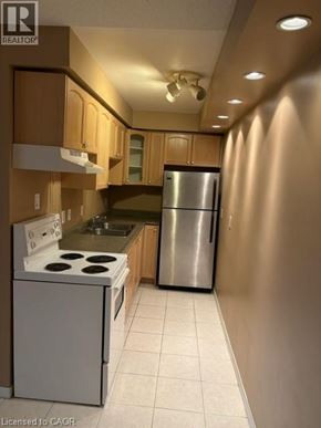 Hamilton condo for rent - A kitchen with a stove, refrigerator, and cabinets.