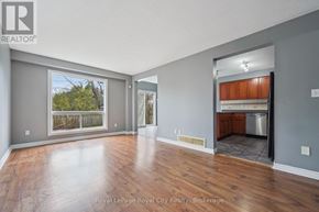 Guelph (Kortright West) apartment for rent - A spacious room with wooden floors and a sliding glass door leading to a balcony.