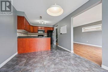 Guelph (Kortright West) apartment for rent - A kitchen with a brown counter top and grey tiled floor.