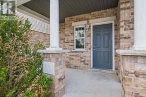Guelph (Kortright West) apartment for rent - A house with a dark blue door and a number 30 on a stone pillar.