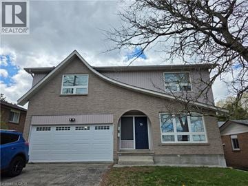 Guelph apartment for rent - A house with a blue car parked in front.